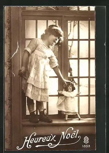 AK Mädchen steht mit seiner Puppe am Fenster, Heureux Noel!