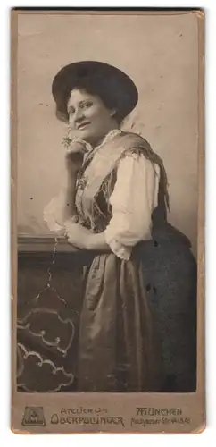 Fotografie Atelier Oberpollinger, München, Neuhauserstr. 44, Portrait charmant lächelnde Dame mit Hut im Trachtenkleid