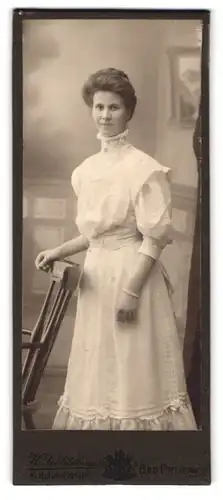 Fotografie H. Schlitzberger, Bad Pyrmont, Portrait brünette junge Frau im elegant gerüschten Kleid