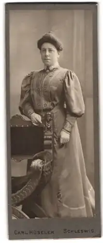 Fotografie Carl Hüseler, Schleswig, Portrait brünette junge Frau mit Dutt im bestickten Kleid