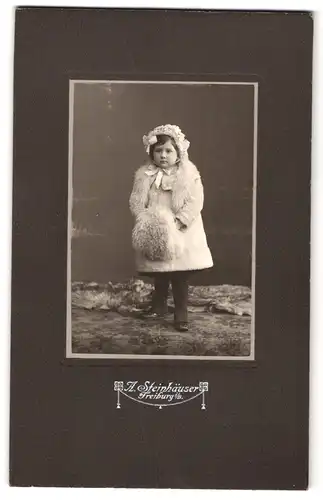 Fotografie A. Steinhäuser, Freiburg i. B., Portrait kleines Mädchen im Wintermantel mit Muff und Pelzstola