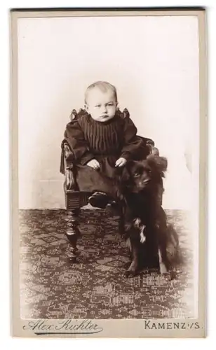 Fotografie Alex. Richter, Kamenz i. S., Missmutig blickendes Kind mit schwarzem Hund