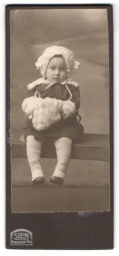 Fotografie Atelier Stein, Berlin, Chausseestr. 70 /71, Portrait Kleinkind im Winterkleid mit Muff und Wollmütze