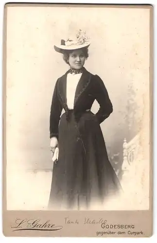 Fotografie L. Gahre, Godesberg, gegenüber dem Curpark, Portrait junge Frau im schwarzen Kleid mit Bolero und breitem Hut