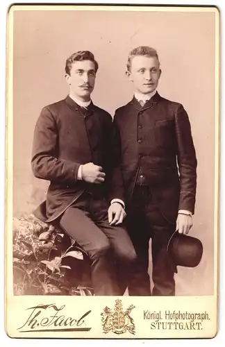 Fotografie Th. Jacob, Stuttgart, Portrait zwei Herren in Anzügen mit Melone und Moustache