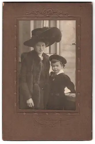 Fotografie Ernst Matthes, Nürnberg, Portrait Mutter im Pelzkleid mit Sohn im samtenen Anzug mit Hut, Federhut