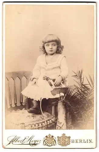 Fotografie Albert Meyer, Berlin, Alexander-Str. 45, Portrait blondes Mädchen im Marinekleid mit Spielzeugpferd u. Locken