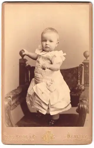 Fotografie Fritz Leyde & Co., Berlin, König Str. 31, Portrait kleines Kind Mia Reckwitz im weissen Kleid mit Schleifen