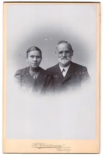 Fotografie H. Christmann, Warburg, Portrait älterer Herrschaften im Anzug und Kleid mit Vollbart und Ohrringe