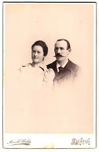 Fotografie Arnold Seiler, Liestal, vor dem oberen Thor, Portrait Frau und Mann im Kleid und Anzug mit Spitzbart