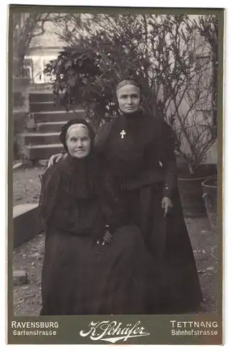 Fotografie K. Schäfer, Ravensburg, Gartenstr., Portrait zwei ältere Damen in schwarzen Kleidern mit Haube und Kreuzkette