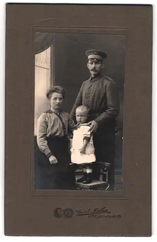 Fotografie Carl Müller, Leer, Wilhelmstrasse 65, Soldat in Feldgrau mit Frau und Kind