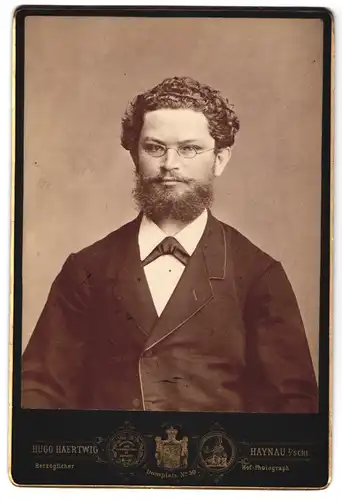 Fotografie Hugo Haertwig, Haynau i/Schl., Portrait vollbärtiger Mann in Jacke mit Brille
