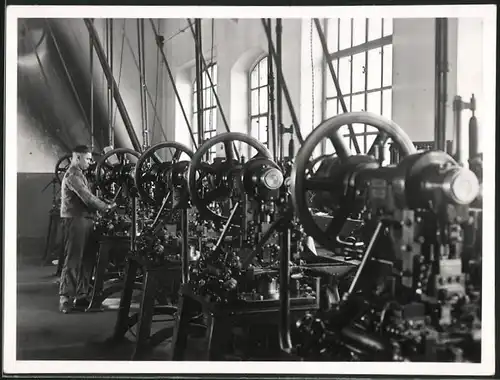 Fotografie Schlosser bedient Stanz - und Lochmaschinen mit Riementrieb