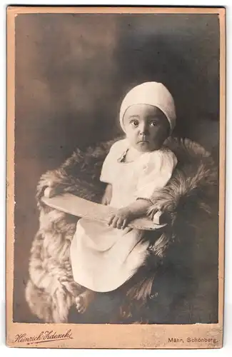 Fotografie Heinrich Zdenek, Mähr. Schönberg, Portrait süsses Kleindkind mit weisser Mütze