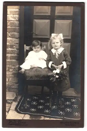 Fotografie Wilh. Boos, Pfarrkirchen, Portrait zwei süsse Mädchen in hübschen Kleidern vor der Haustür stehend