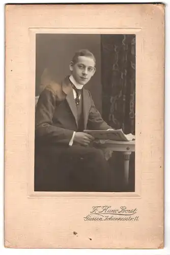 Fotografie F. Kuno Borst, Giessen, Johannesstr. 11, Portrait charmanter junger Mann mit Zeitschrift in den Händen
