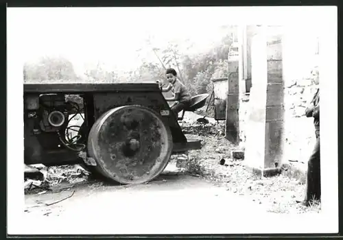 Fotografie Strasenwalze, Knabe auf Führerstand der Baumaschine