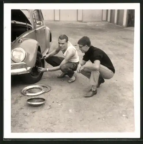 Fotografie Auto VW Käfer, Bursche fummelt am äusseren Radlager herum