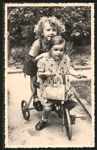 Fotografie niedliches Mädchen mit Handtasche fährt Dreirad