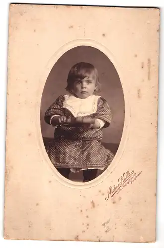 Fotografie Atelier Kolbe, Ort unbekannt, Portrait süsses Kleinkind im gepunkteten Kleidchen