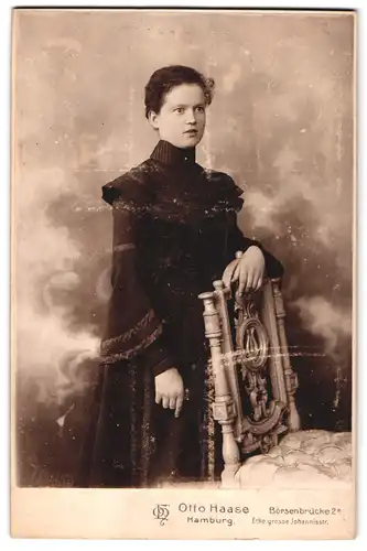 Fotografie Otto Haase, Hamburg, Börsenbrücke 2a, Portrait dunkelhaariges Fräulein im Kleid am Stuhl stehend