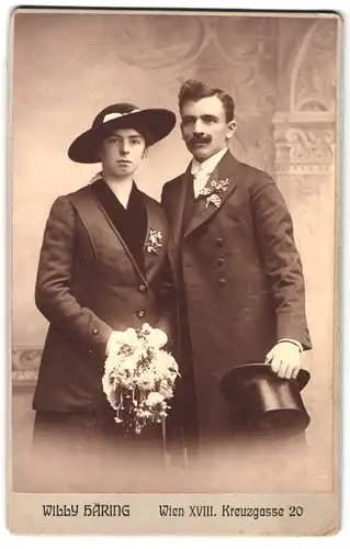 Fotografie Willy Häring, Wien, Kreuzgasse 20, Portrait junges Paar in hübscher Kleidung mit Blumenstrauss