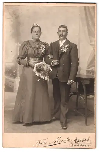 Fotografie Fritz Moritz, Passau, Bahnhofstrasse, Portrait junges Paar in Hochzeitskleidung mit Blumenstrauss