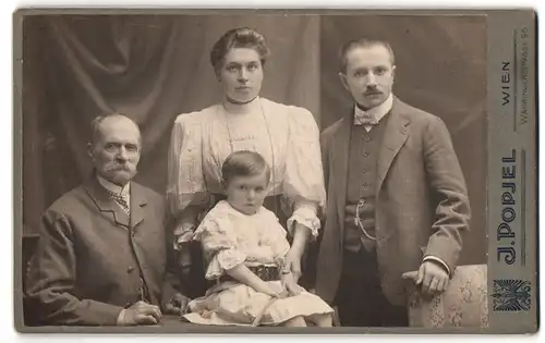 Fotografie J. Popjel, Wien, Währingerstrasse 96, Portrait älterer Herr und junges Paar mit Kind in hübscher Kleidung
