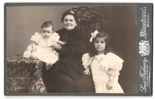 Fotografie Louis Frohwein, Mannheim, Breitestrasse, Portrait ältere Dame in hübscher Kleidung mit Mädchen und Kleinkind
