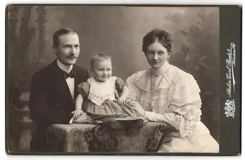 Fotografie Carl Beste, Minden i /W., Portrait elegantes Paar mit einem Kleinkind