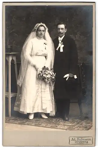 Fotografie Ad. Hofmann, Straubing, Portrait junges Paar in Hochzeitskleidung mit Schleier und Blumenstrauss