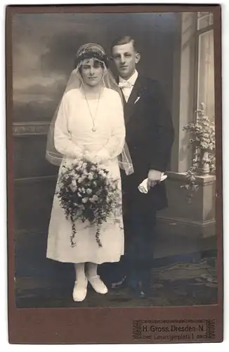 Fotografie Herm. Gross, Dresden-N, Leisnigerplatz 1, Portrait junges Paar in Hochzeitskleidung mit Blumenstrauss