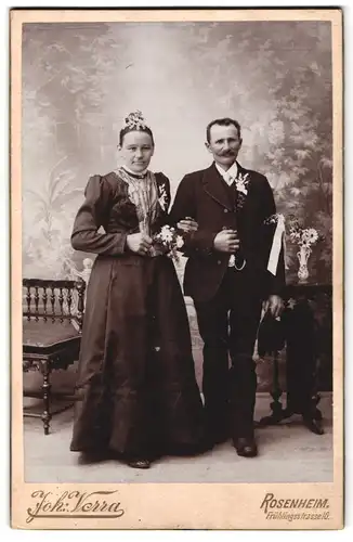 Fotografie Joh. Verra, Rosenheim, Frühlingsstrasse 10, Portrait bürgerliches Paar in hübscher Kleidung mit Blumen