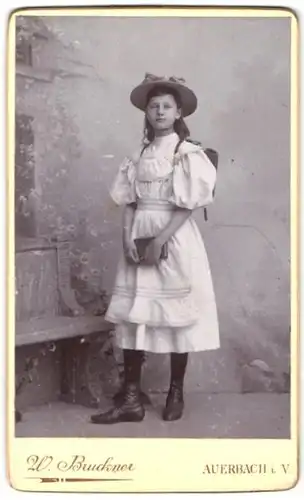 Fotografie W. Buckner, Auerbach i. V., Portrait Mädchen im Kleid mit Schulranzen zum Schulanfang