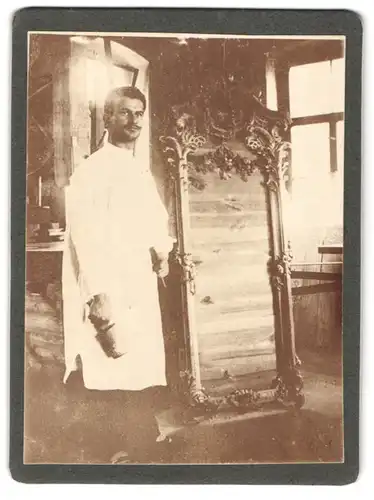 Fotografie unbekannter Fotograf und Ort, Schreiner beim Bosselieren eines Rahmens in seiner Werkstatt mit Holzklüpfel