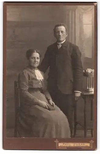 Fotografie Paul Cliese, Reichenau i. S., Hauptstr., Portrait Ehepaar im Anzug und Biedermeierkleid