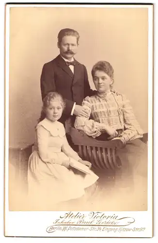 Fotografie Atelier Victoria, Berlin, Potsdamer-Str. 34, Portrait Mutter und Vater mit Tochter in Kleidern und Schnauzer