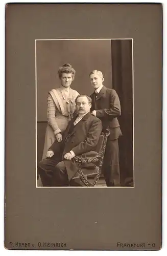Fotografie P. Krabo u. O. Heinrich, Frankfurt a. O., Wilhelmsplatz 20, Portrait Mutter und Vater mit Sohn im Anzug