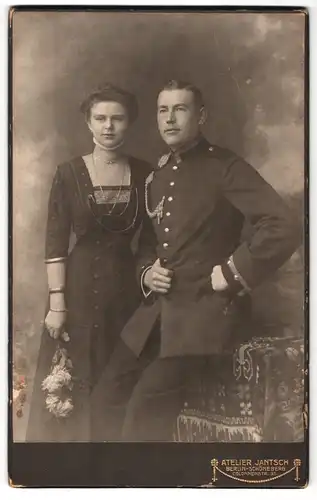 Fotografie Atelier Jantsch, Berlin, Colonnenstr. 35, Portrait Uffz. in Uniform mit Schützenschnur nebst seiner Frau