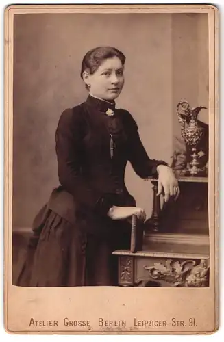 Fotografie Atelier Grosse, Berlin, Leipziger-Str. 91, Portrait junge Frau im Biedermeierkleid steht am Sekretär