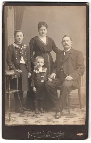 Fotografie Atelier C. Römmert, Helbra, Portrait Familie mit zwei Kindern in Matrosenanzügen posieren im Atelier