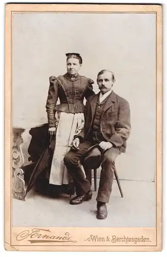 Fotografie Fernande, Wien, Portrait Frau und Mann im Biedermeierkleid und karierten Anzug mit Hut und Schirm