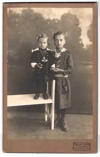 Fotografie F. W. Reng, Neuötting a. Inn, Portrait zwei Mädchen im Samtkleid und gestreiftem Kleid mit Haarschleife