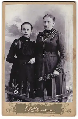 Fotografie A. Wehle, Zittau i. S., Hospitalstr. 8, Portrait Mutter mit Tochter in dunklen Kleidern vor Studiokulisse