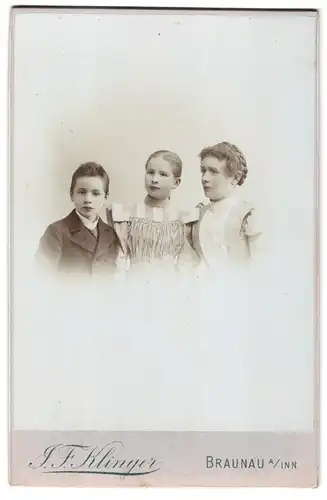 Fotografie J. F. Klinger, Braunau a. Inn, Portrait Mutter mit zwei Kindern in Kleidern und Anzug, Zopf