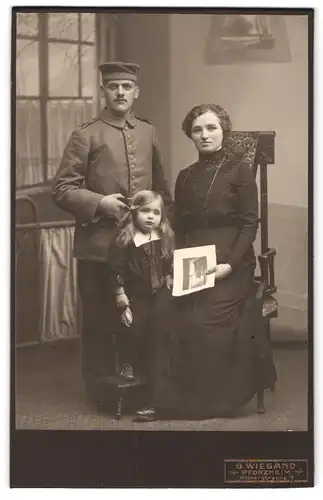 Fotografie B. Wiegand, Pforzheim, Weiherstrasse 9, Portrait Soldat in Uniform mit Frau und Tochter