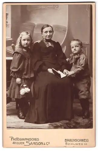 Fotografie Samson und Co., Braunschweig, Bohlweg 66, Grossmutter mit zwei jungen Kindern in dunkler Kleidung