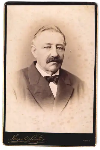 Fotografie Leopold Bude, Graz, Portrait Älterer Herr mit Schnurrbart im Anzug