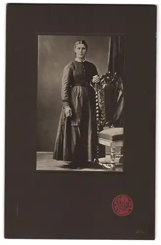 Fotografie E. Steiger, Moers, Portrait Dame im dunklen Kleid neben einem Biedermeierstuhl